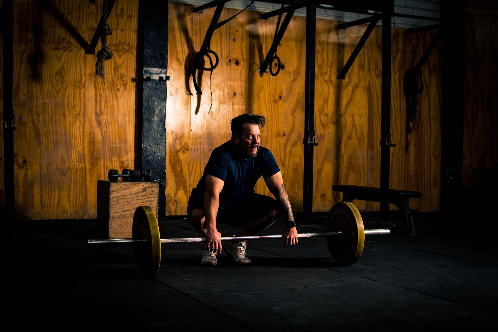 Lifter preparing a heavy deadlift in a dimly lit gym — trenbolone vs nandrolone guide
